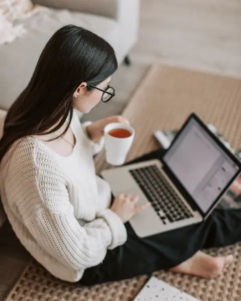 Femme buvant un thé au bureau avec ordinateur